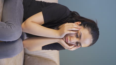 Vertical-video-of-Depressed-young-woman-covering-her-face-with-her-hand.